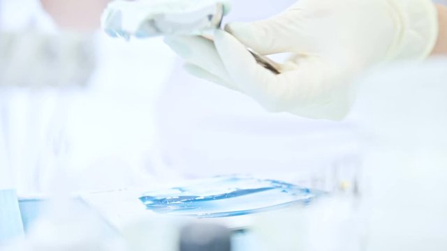 Close-up of the hand of dentistry mix components for a composite preform for removing the form from the jaw and the bite of the patient