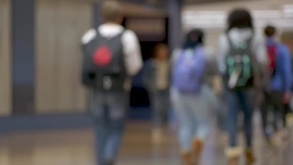Blurred, out of focus shot of multi-ethnic teenage high school students walking in the hall of their school. ProRes file, shot in 4K UHD.