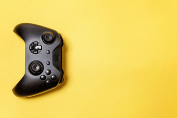 Black joystick gamepad, game console on yellow colourful trendy modern fashion pin-up background. Computer gaming competition videogame control confrontation concept. Cyberspace symbol