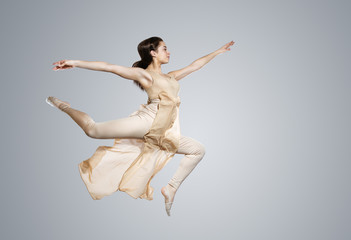 Ballerina. A young graceful ballet dancer dressed in professional attire demonstrates dancing skills. Modern dance
