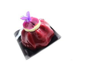 Red fruit dessert with edible purple pea flower