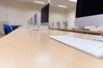 Modern office with computers on desks. Empty computer room in college. Interior of classroom with computers. Concept of corporate working space.