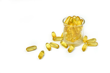 Close up to gold fish oil capsules isolated in a glass bottle on white background. Omega 3. Vitamin E. Capsules salmon fish oil view. Supplementary food background.