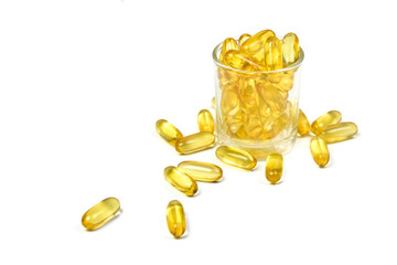 close up of gold pile fish oil capsules isolated on white background. Capsules salmon fish. Omega 3. Vitamin E. Supplementary food background view.