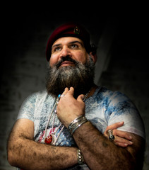  Ein Mann mit Bart, rotem Hut und Ringen aus Edelsteinen, Ketten und Accessoires