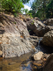 Fototapeta na wymiar Water flows over the rocks of the waterfall on Koh Phangan. Thailand