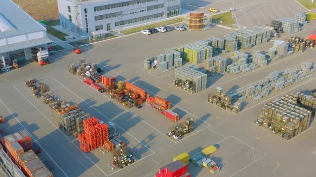 Aerial side view of the outside storage (storage yard) of a modern bright building and structural materials