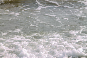 white soft wave rolling splash on empty tropical sandy beach in sunny day