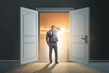 Puzzled businessman in front of big door