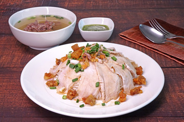 Slice grilled pork with rice, topping with fried pork rinds, pickled garlic and spring onions served with pork spare ribs soup and green spicy chili sauce. Famous Chinese / Cantonese cuisine.