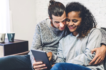 Young couple relaxing and using tablet computer.Couple checking social apps and working.Communication and technology concept