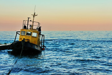 Obraz premium fishing boat at sunset