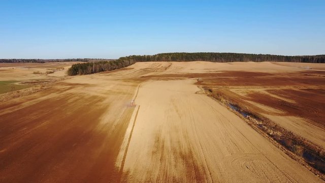 4K. Aerial view of agriculture process: tractors are plows and makes seeding, sowing agricultural crops at field.