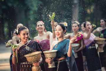 Vientiane Laos APRIL 4 2019 : Young happy beauty Asian woman splashing water during  Water Songkran festival ,Thailand Laos traditional.