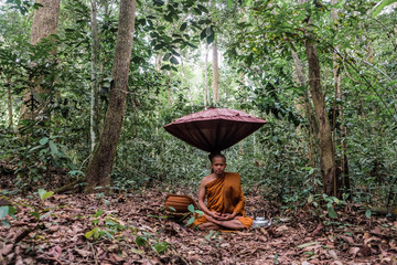 Buddist monk made meditation in deep forest