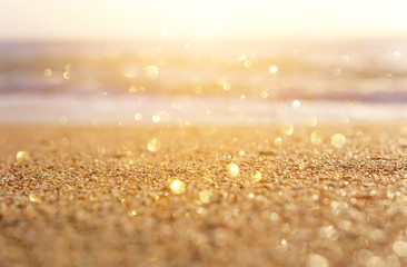 background image of sandy beach and ocean waves with bright bokeh lights