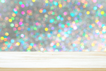 Photo of old wooden table in front of white and silver glitter lights background. Ready for product...