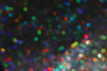 Naklejka premium glitter black lights background with colorful bokeh. de-focused