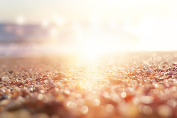 background image of sandy beach and ocean waves with bright bokeh lights