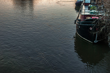 A boat that is parked on the banks of the River Thames