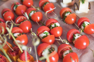 Tasty and juicy snacks for buffet table: mini burgers, canapés, fruit, sliced and baked