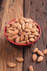 Almond nut in a ceramic bowl against wooden table