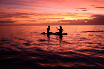 Two girls during sunset on a paddle board