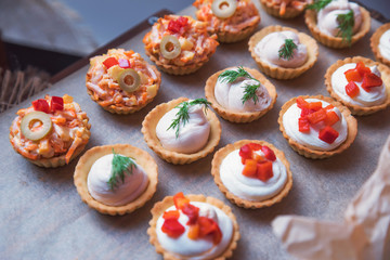 Tasty and juicy snacks for buffet table: mini burgers, canapés, fruit, sliced and baked