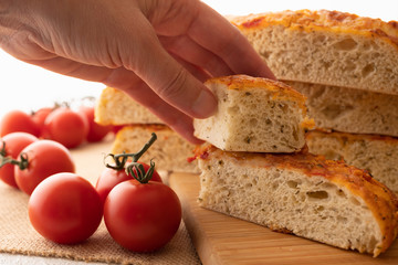 Focaccia, Italian Homemade Bread, and Tomatoes Close Up on a Wooden Chopping Board