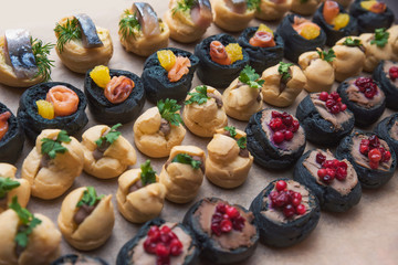 Tasty and juicy snacks for buffet table: mini burgers, canapés, fruit, sliced and baked