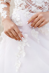 hands of a bride on a wedding dress
