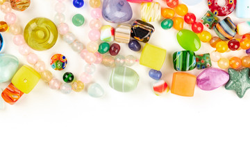 Many different beads, shot from above on a white background with a place for text