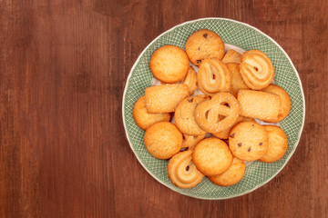 Danish butter cookies, shot from above on a dark rustic wooden background with copy space