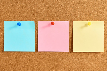 Cork board with a pinned colored blank notes