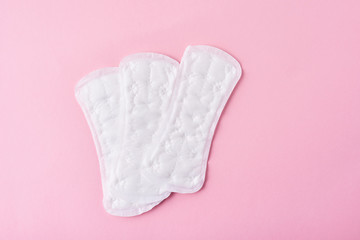 Sanitary pads on a pink background, top view