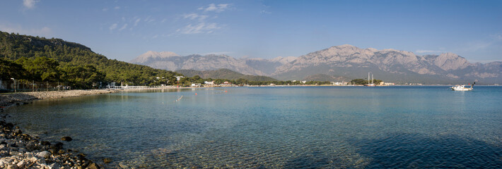 Kemer Antalia nice view of the sea. Beach Kemer Antalia with sand and mountains, the sea with the ship. Beautiful harbor near the sandy beach.