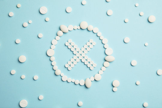 Stop symbol made of white pills on blue background. Medical care, ambulance.