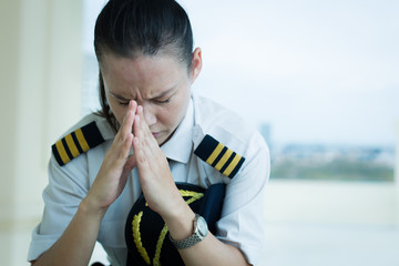 Stressed out female pilot worried at work. © globalmoments