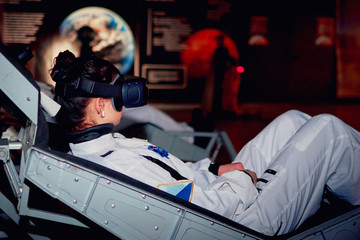 Girl in space simulator for sastronauts or cosmonauts with a virtual reality glasse