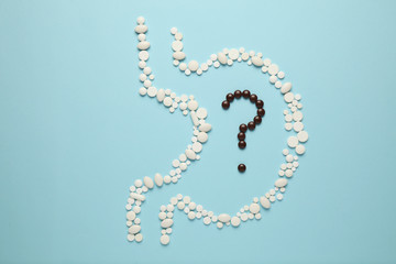 Human stomach from tablets, question mark in the stomach. Healthy nutrition, metabolism in the body.