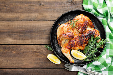 Grilled chicken Tabaka with sauce on  wooden background.