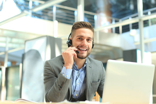 Smiling friendly handsome young male call centre operator.