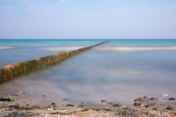 long groynes protrude into the water of the blue Baltic Sea