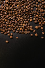 Roasted coffee beans in bulk on a black background. dark cofee roasted grain flavor aroma cafe, natural coffe shop background, top view from above, copy space