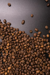 Roasted coffee beans in bulk on a black background. dark cofee roasted grain flavor aroma cafe, natural coffe shop background, top view from above, copy space