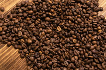 Roasted coffee beans in bulk on a wooden background