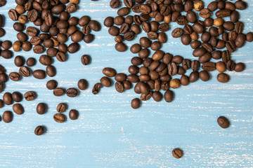 Roasted coffee beans in bulk on a blue wooden background. dark cofee roasted grain flavor aroma...