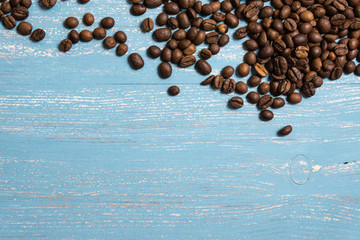 Roasted coffee beans in bulk on a blue wooden background. dark cofee roasted grain flavor aroma...