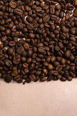Roasted coffee beans in bulk on a light pink background. dark cofee roasted grain flavor aroma...