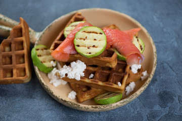 Belgian waffles with trout fillet, grilled zucchini slices and ricotta cheese over blue stone...